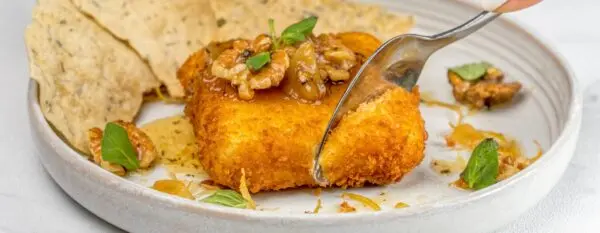 A piece of chicken being eaten with a spoon