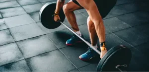 Man deadlifting a barbell with plates