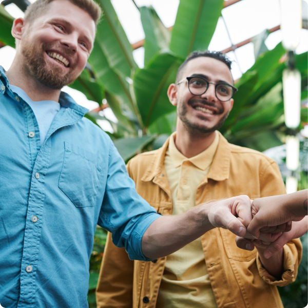 Two friends greeting others with a fist bump