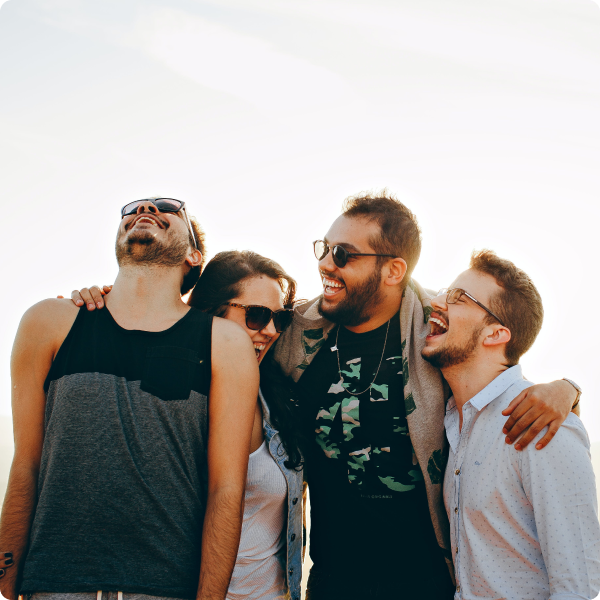 A group of friends standing in the sun laughing