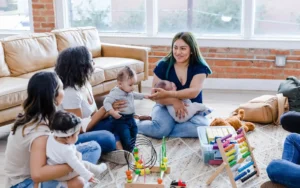 New moms, sitting with their children playing with toys